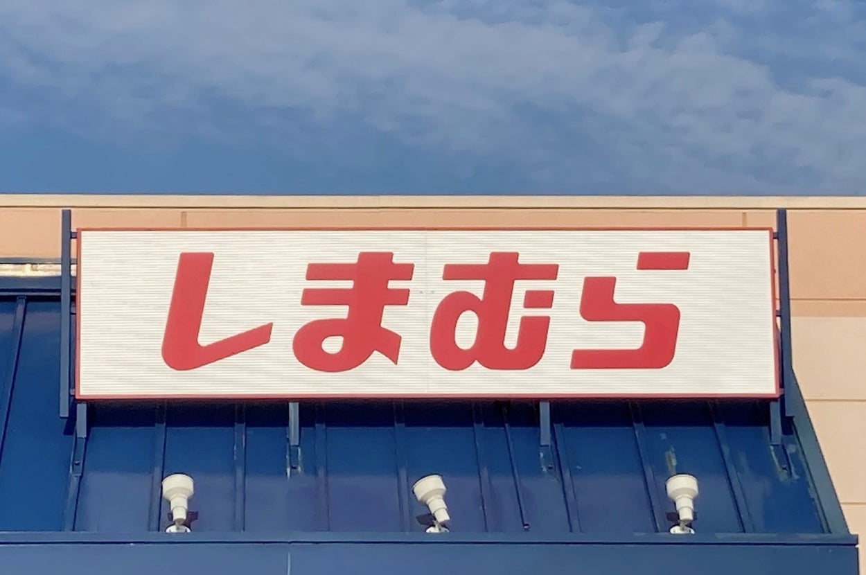 Storefront sign with stylized Japanese characters reading "しまむら" above an accessible entrance