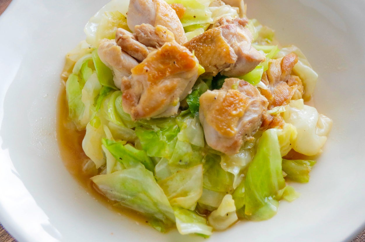 鶏肉とキャベツの炒め物が白い皿に盛られている。