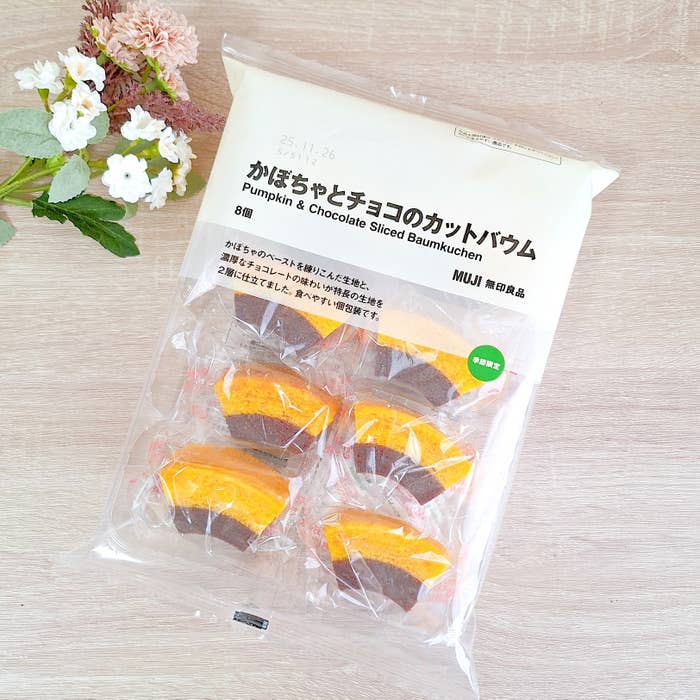 袋入りのかぼちゃとチョコのカットバウム、商品説明と花が添えられている。