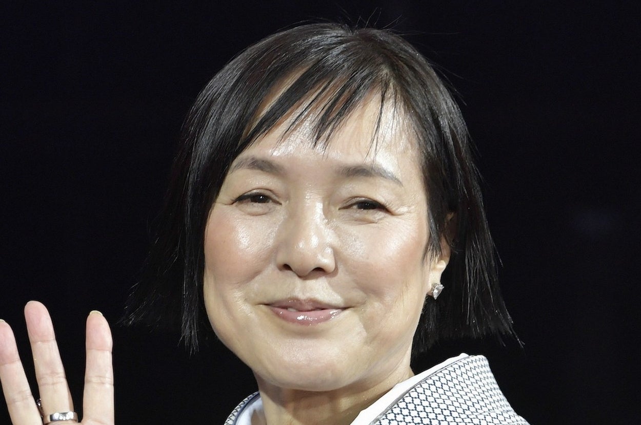 着物を着た女性が手を振っている。