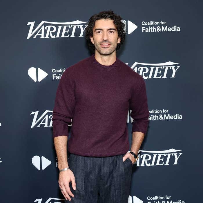 Person successful a sweater and trousers connected a reddish carpet, posing astatine a Variety lawsuit backdrop