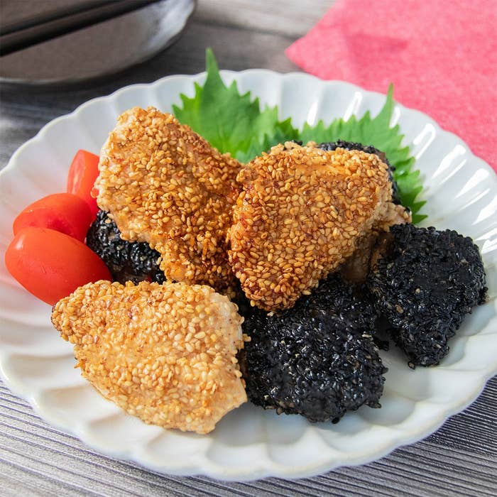 皿に盛られた鶏むね肉のごま衣唐揚げとプチトマト。大葉の飾りが添えてある。