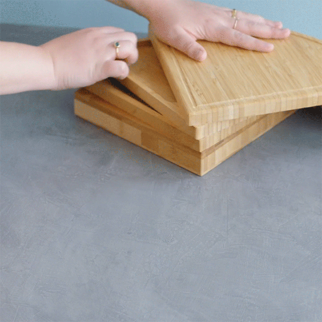 Hands show  nesting cutting boards connected  a room  counter, suggesting a compact retention  solution