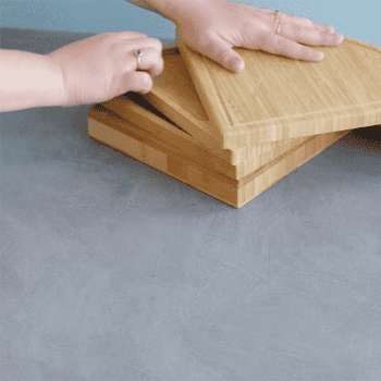 Hands show nesting cutting boards connected a room counter, suggesting a compact retention solution