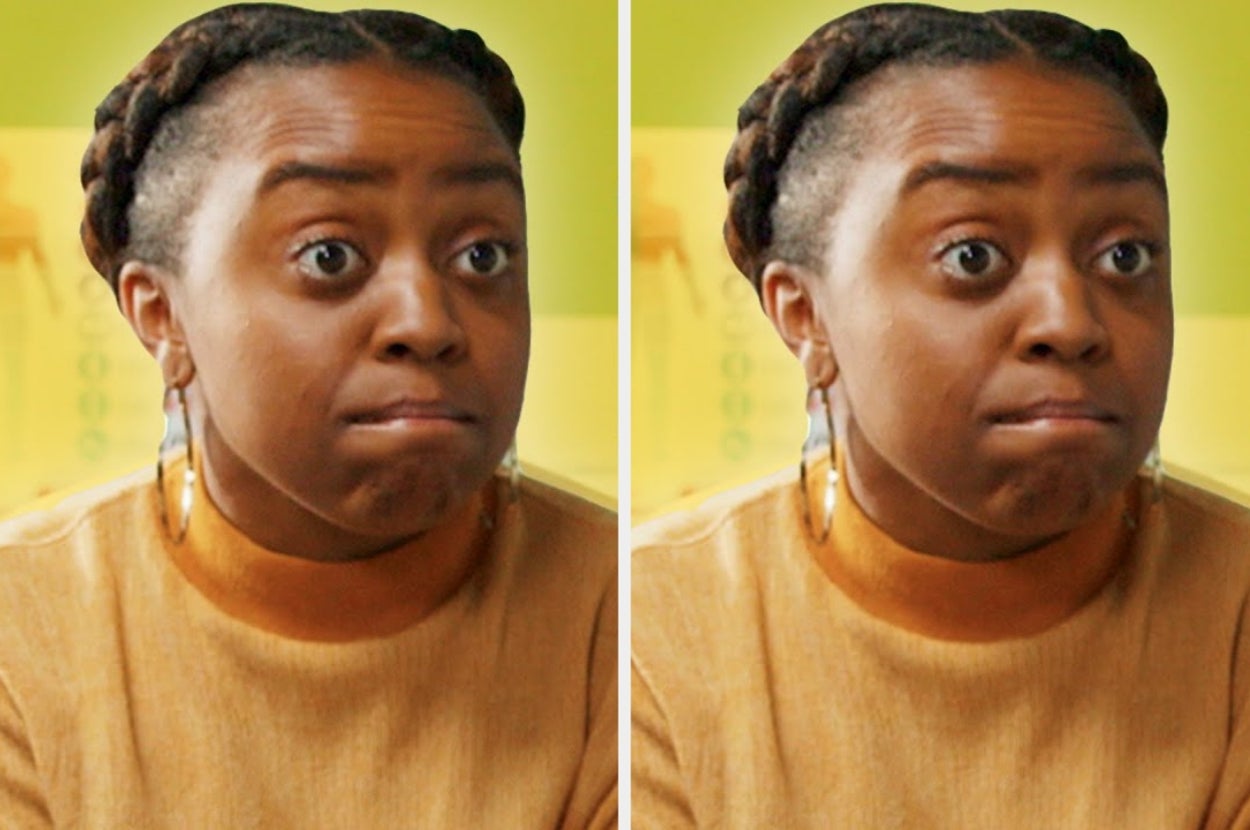 A person with braided hair and large hoop earrings looks surprised or concerned, wearing a light top with a high neckline