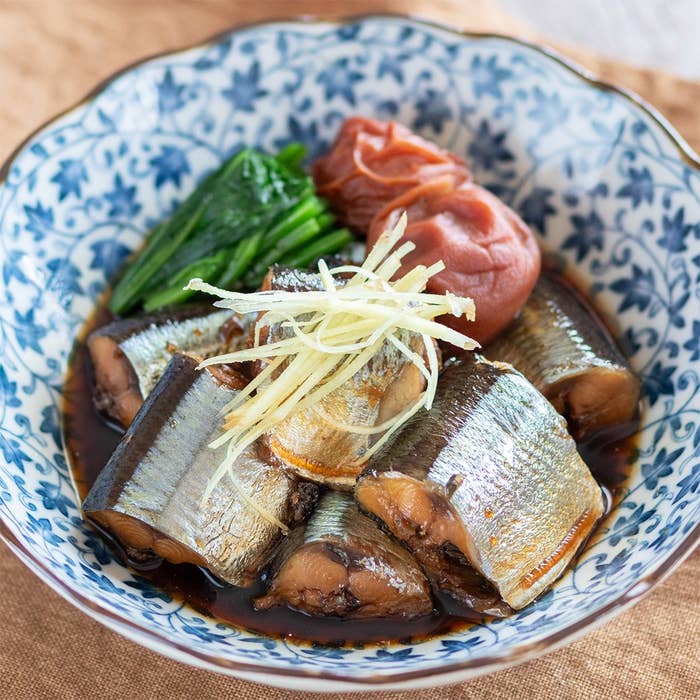 和風の器に盛られた煮魚、梅干し、青菜が盛り付けられた料理。食欲をそそる見た目。