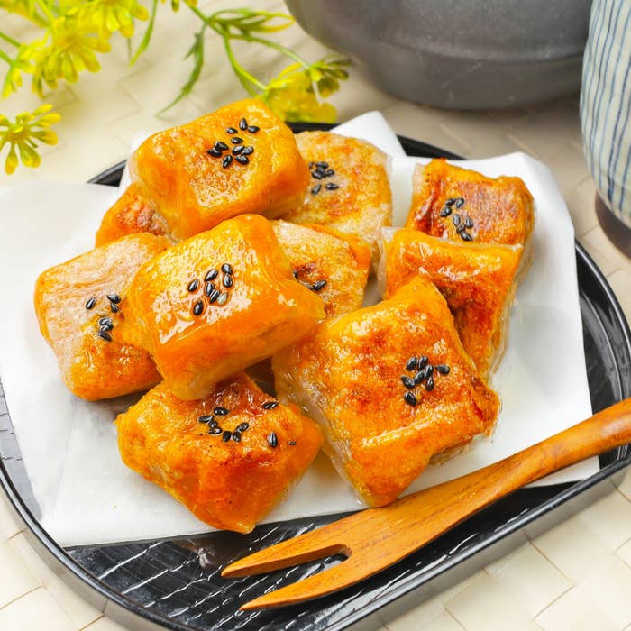 お皿に盛られた少し光沢のある香ばしそうな焼き菓子。上に黒ごまが散らされています。