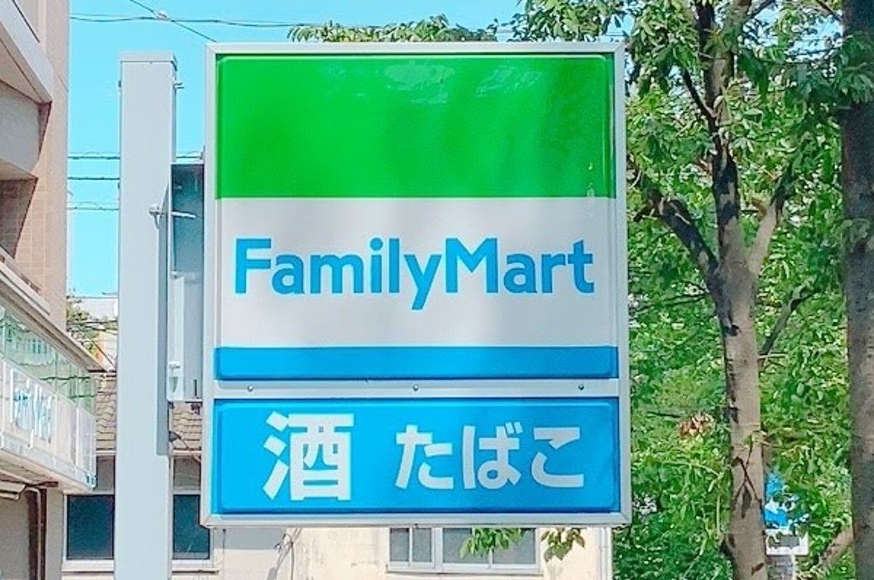 FamilyMartの看板が映る、酒やたばこを取り扱うコンビニ店舗の外観。