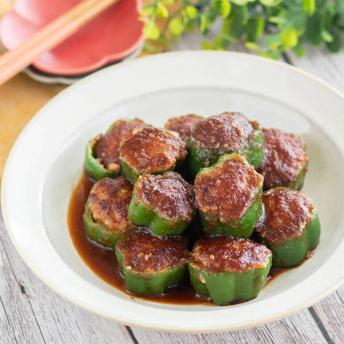 お皿に盛られたピーマンの肉詰め料理。ソースがかかっており、美味しそうに調理されている。