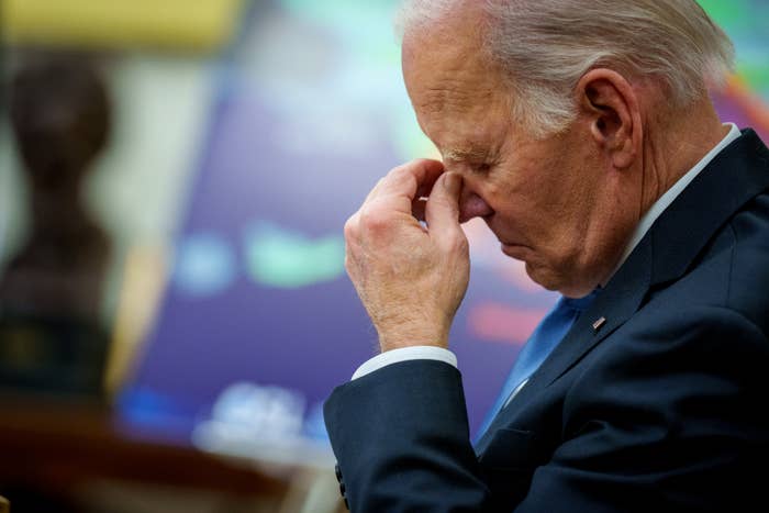 Joe Biden successful a suit is seen with eyes closed, touching their nose, appearing thoughtful oregon concerned. Perspective shows them successful profile