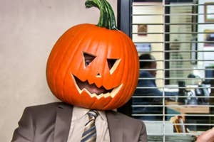 Person in an office wearing a carved pumpkin as a mask, seated in front of a window with blinds