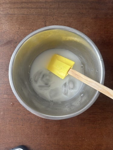 ボウルの中に黄色のスパチュラと小さな氷の塊が入っている。