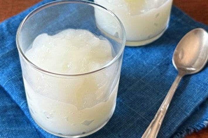 2つのコップに入った氷と飲み物、青い布の上に置かれ、横にスプーンがある。