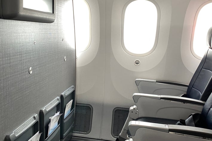 飛行機の座席、窓、収納ポケットが見える機内の様子。