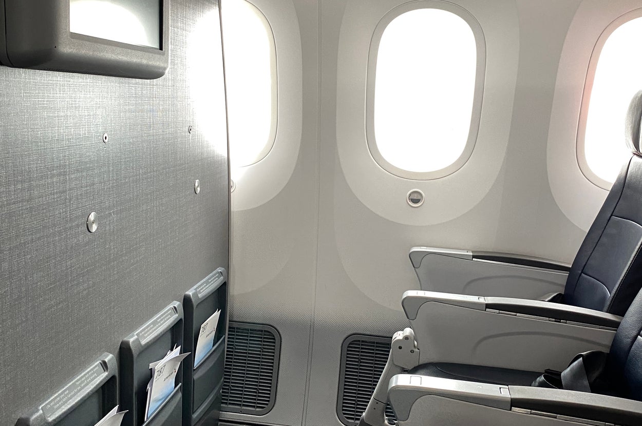 飛行機の座席、窓、収納ポケットが見える機内の様子。