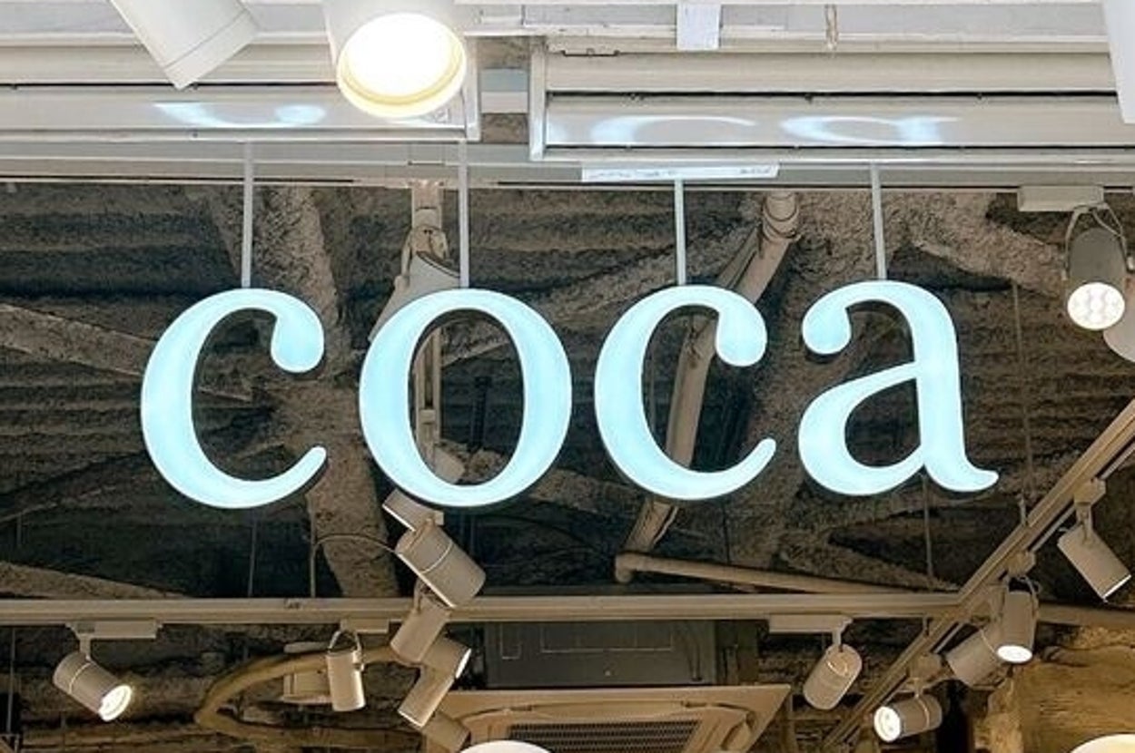 店頭に「coca」の看板。周囲に多数のスポットライトとマネキンが並んでいる。
