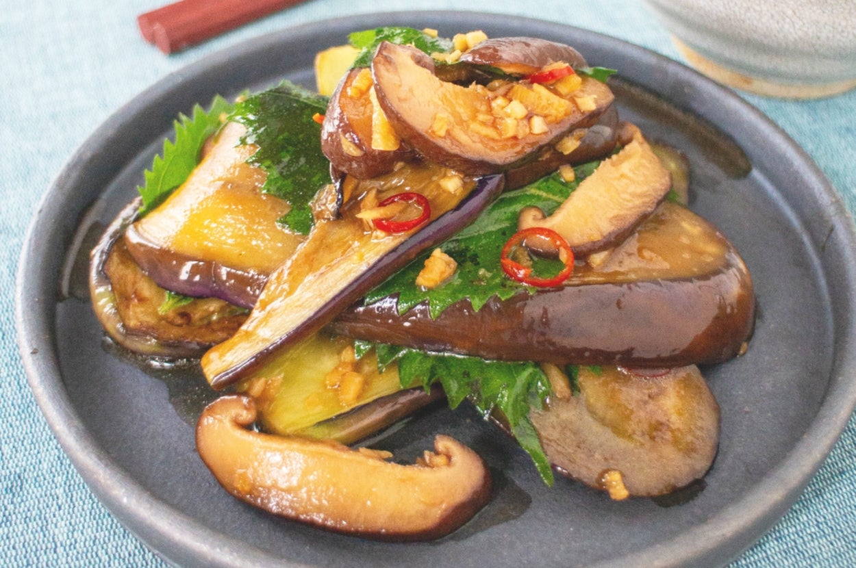 茄子と椎茸を含む料理が皿に盛られ、ご飯が横に置かれた食卓の一部。