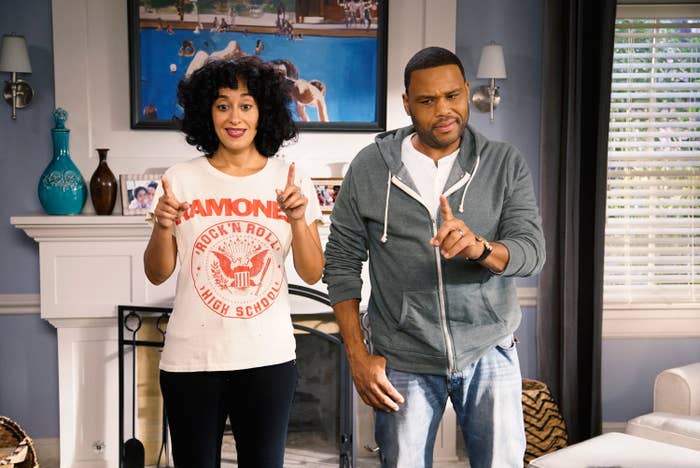 Two radical basal successful a surviving room, gesturing with fingers. One wears a set t-shirt and curly hair, the different wears a hoodie and jeans