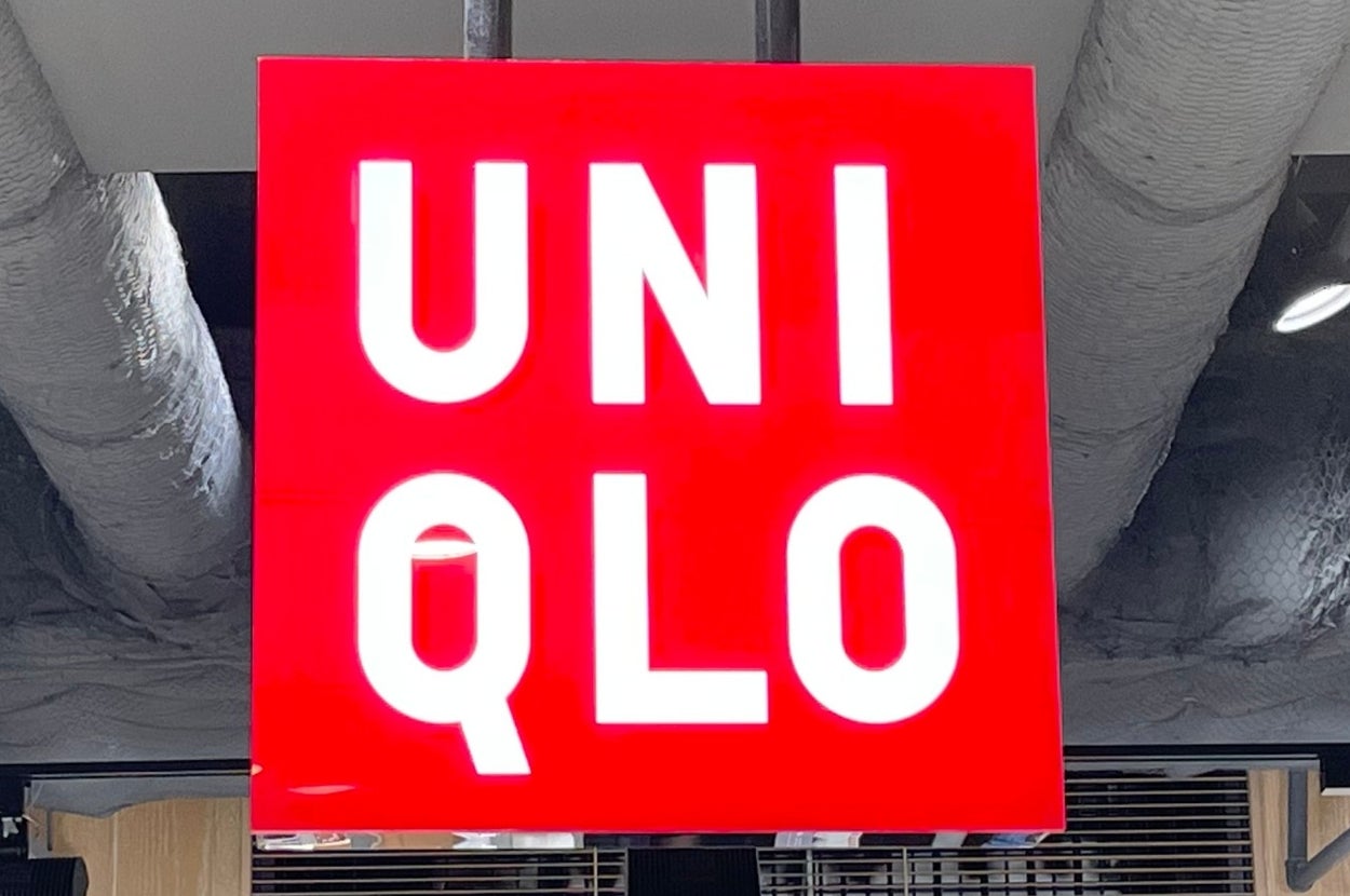 A UNIQLO store sign hangs from the ceiling, with clothing displays and price tags visible in the background