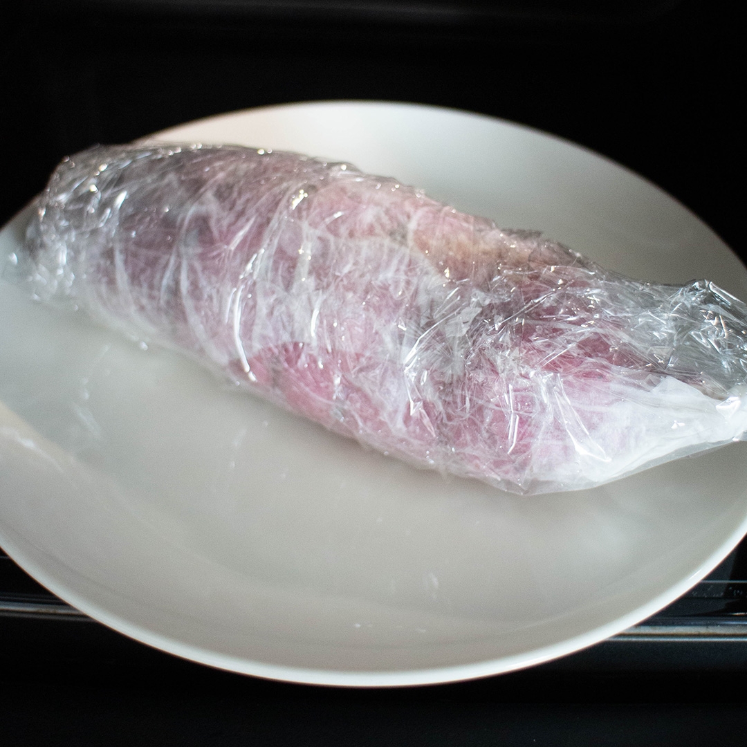 白い皿にラップで包まれた食品。ラップの上から新鮮であることがうかがえる食材。