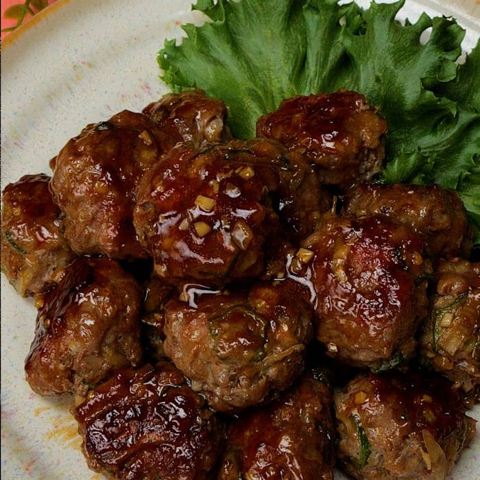 お皿にのった照り焼きソースの肉団子とレタスの添え物。