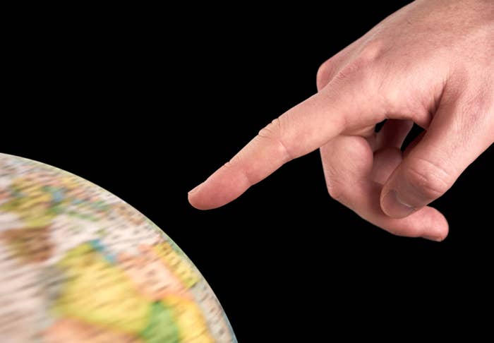 A manus points astatine a spinning globe, suggesting exploration and question planning