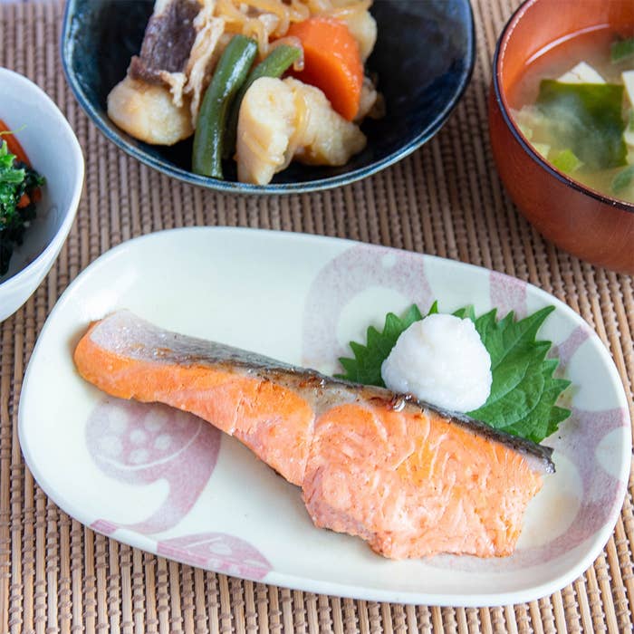 焼きサケ、野菜の煮物、味噌汁などの和食の食卓。