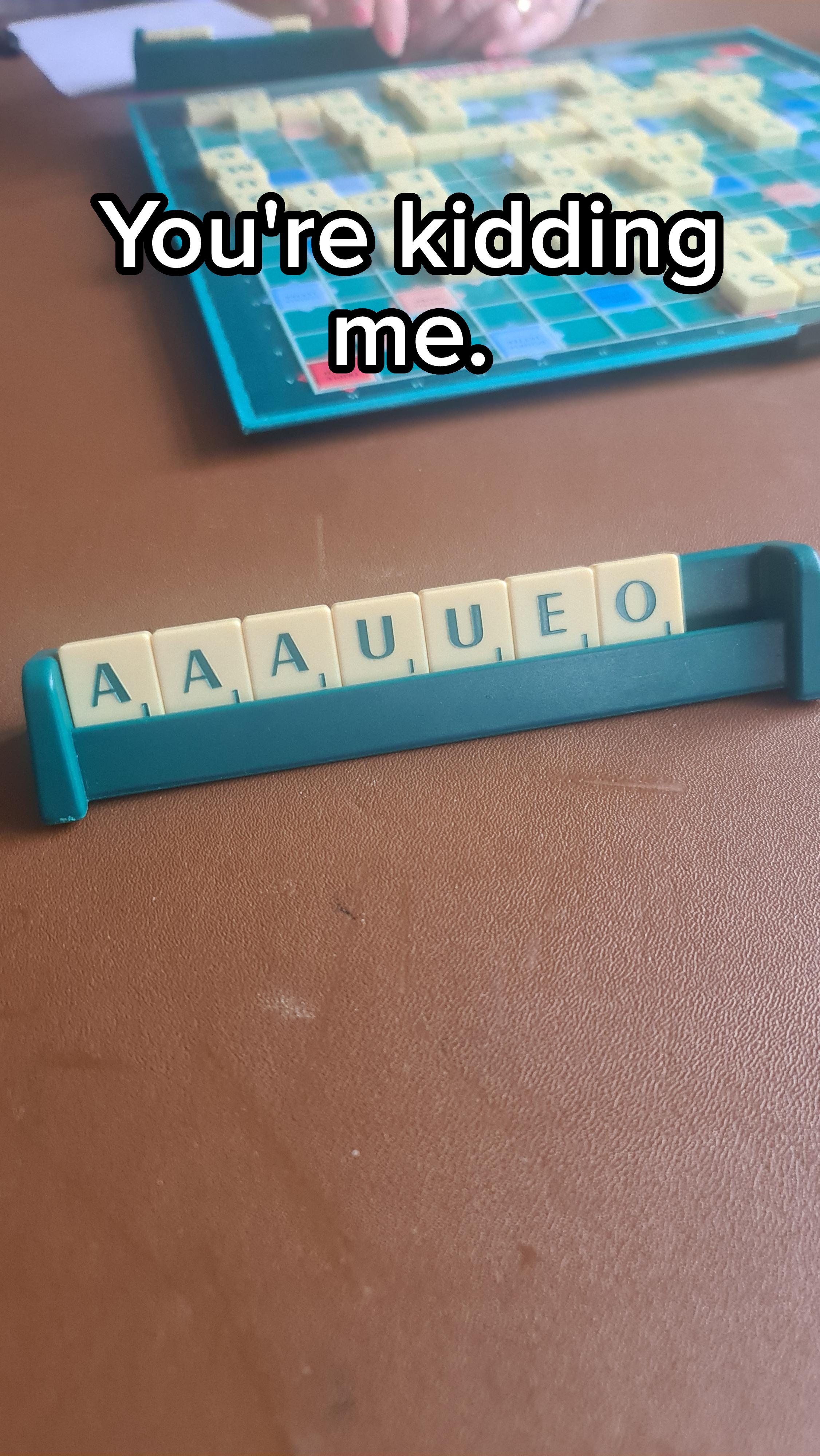 Scrabble game with a tile rack showing letters: A, A, A, U, U, E, O