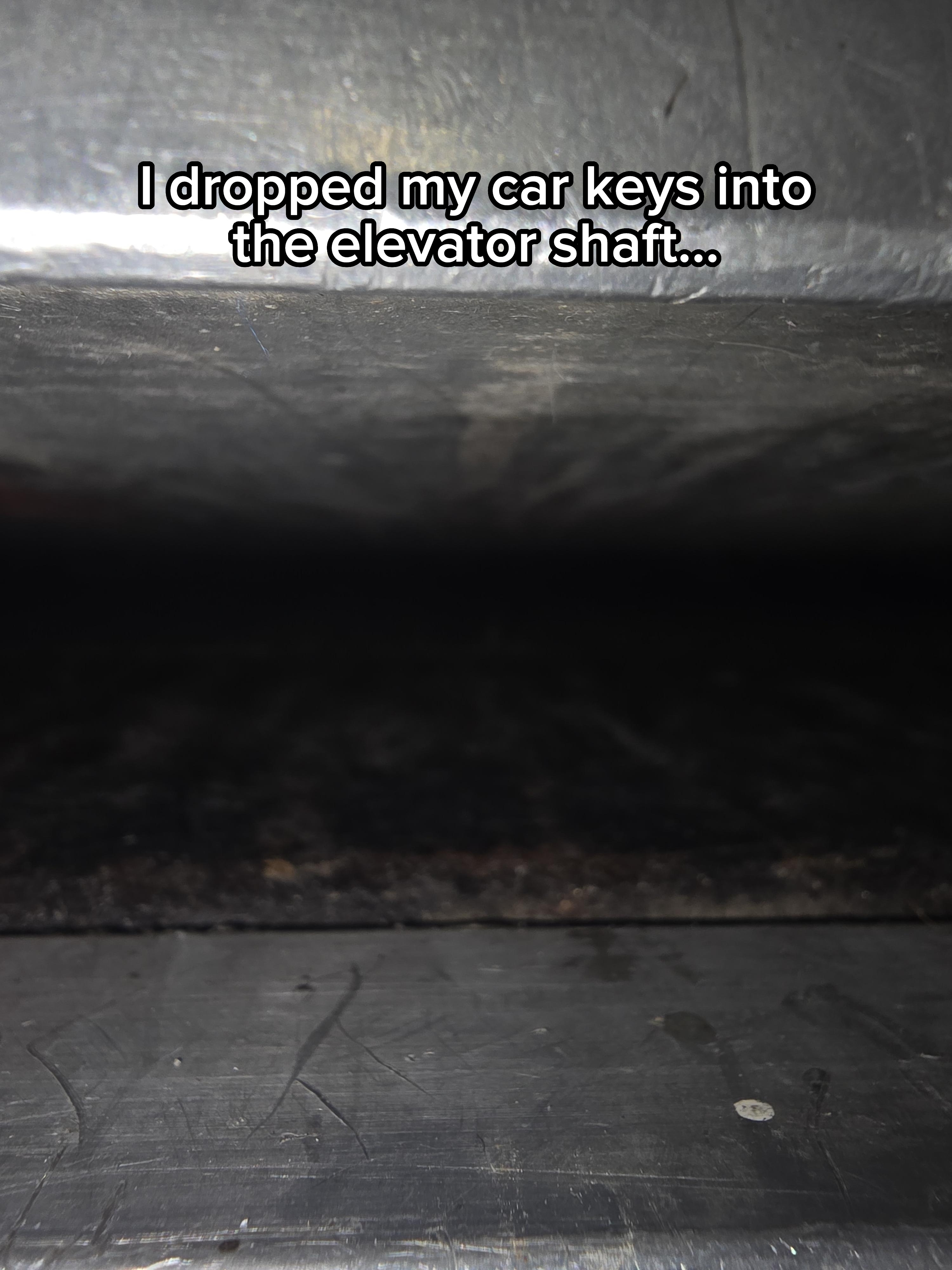 Close-up of a dark, narrow metal space, possibly between two metal surfaces or machines, with limited visibility and no identifiable objects