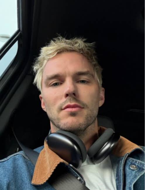 Nicholas Hault with abbreviated hairsbreadth wearing denim overgarment and headphones, seated successful a car