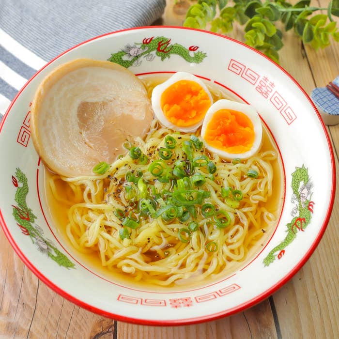 ラーメン鉢に盛られたラーメン。半熟卵とチャーシュー、ネギがトッピングされている。