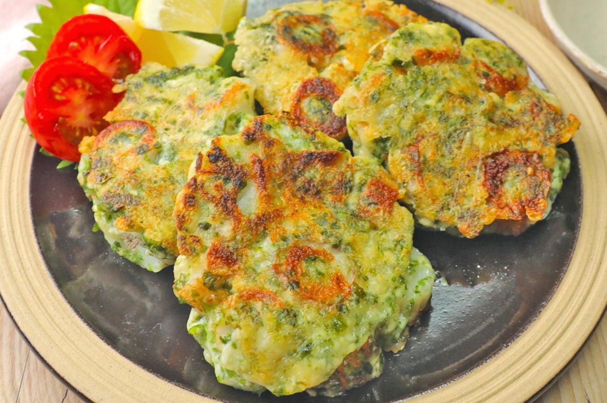 皿に盛られた4枚の野菜入りチヂミ。付け合わせにレモンとトマト。
