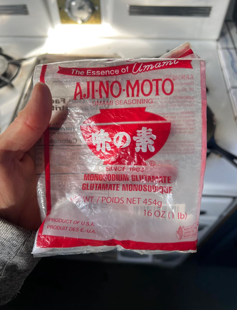 A person holding a red and white packet of Ajinomoto MSG seasoning, with the caption, "MSG is delicious and I put it on everything."