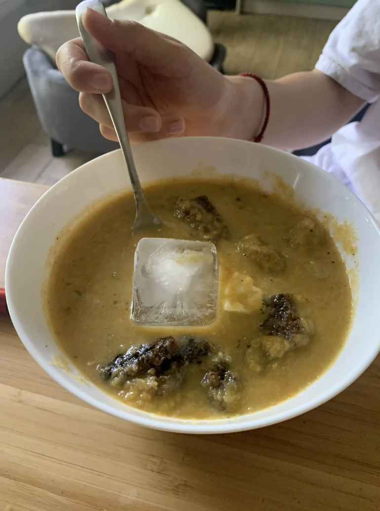 A Reddit post showing a bowl of soup with ice cubes, suggesting a method to cool it down