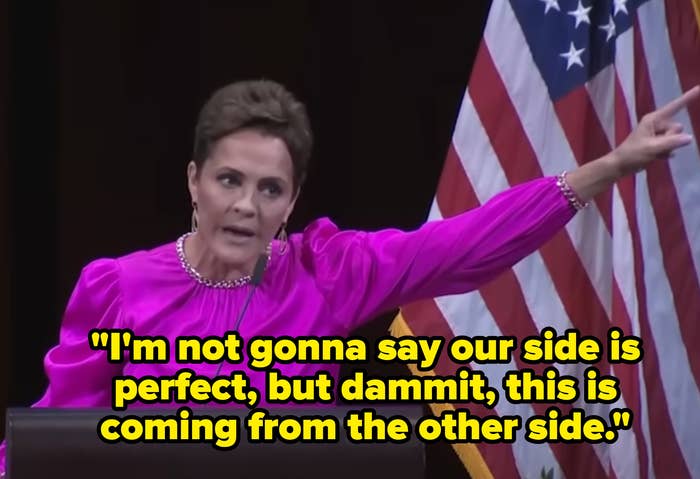 Person astatine podium successful vibrant blouse gestures emphatically beside an American flag, suggesting a dynamic nationalist speaking event