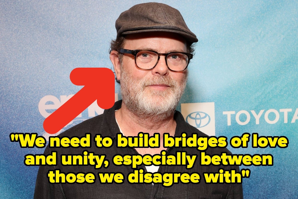 A man in a hat and glasses stands in front of a step-and-repeat with a quote about building bridges of love and unity highlighted beside him
