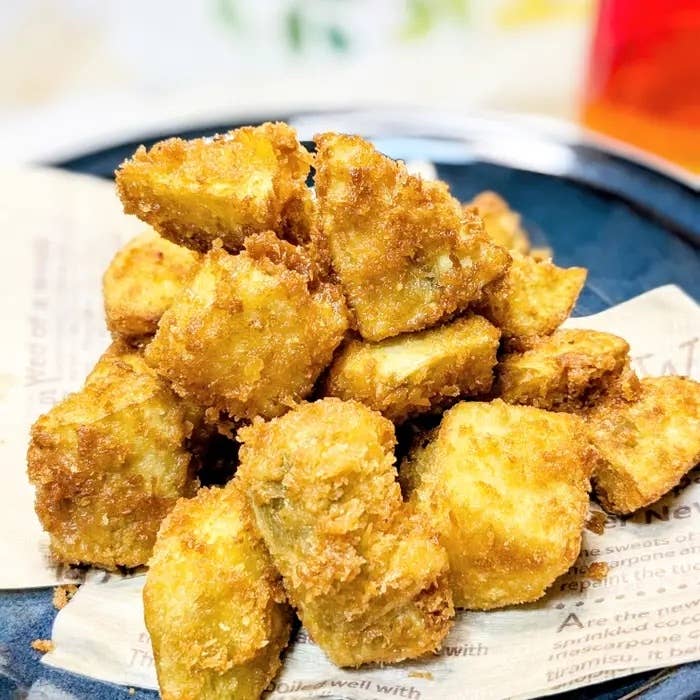 さつまいものパン粉揚げ。一皿の揚げたゴールデンブラウンのさつまいもが紙ナプキの上に置かれている。