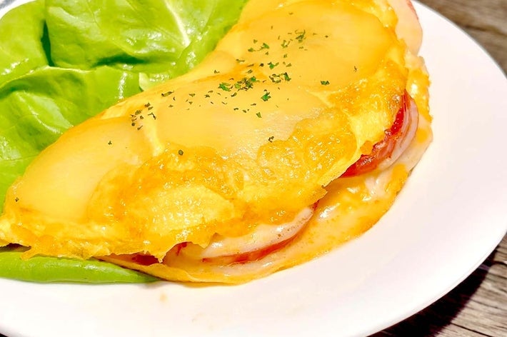オムレツにレタスが添えられた料理。チーズとトマトが中に入っている。