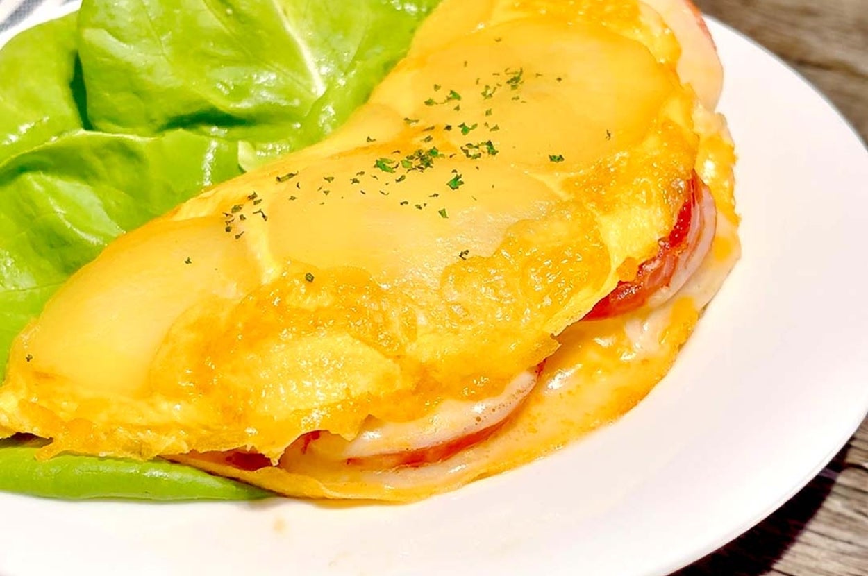 オムレツにレタスが添えられた料理。チーズとトマトが中に入っている。