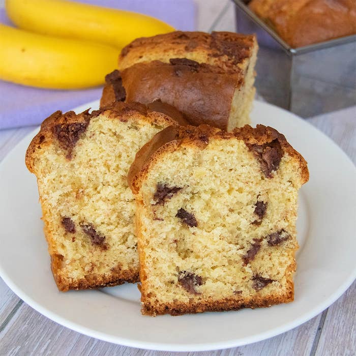 ホットケーキミックスで作ったチョコバナナパウンドケーキ。スライスが白いお皿に盛られている。背景にバナナと型に入った残りのパウンドケーキがある。