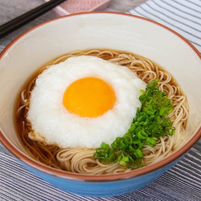 そうめんの上にとろろと卵黄がのり、小ネギが添えられている。