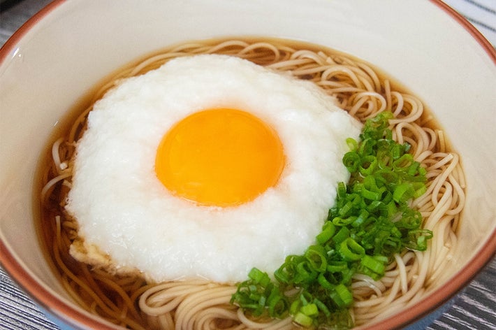 そうめんの上にとろろと卵黄がのり、小ネギが添えられている。