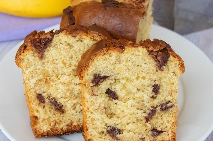 ホットケーキミックスで作ったチョコバナナパウンドケーキ。スライスが白いお皿に盛られている。背景にバナナと型に入った残りのパウンドケーキがある。