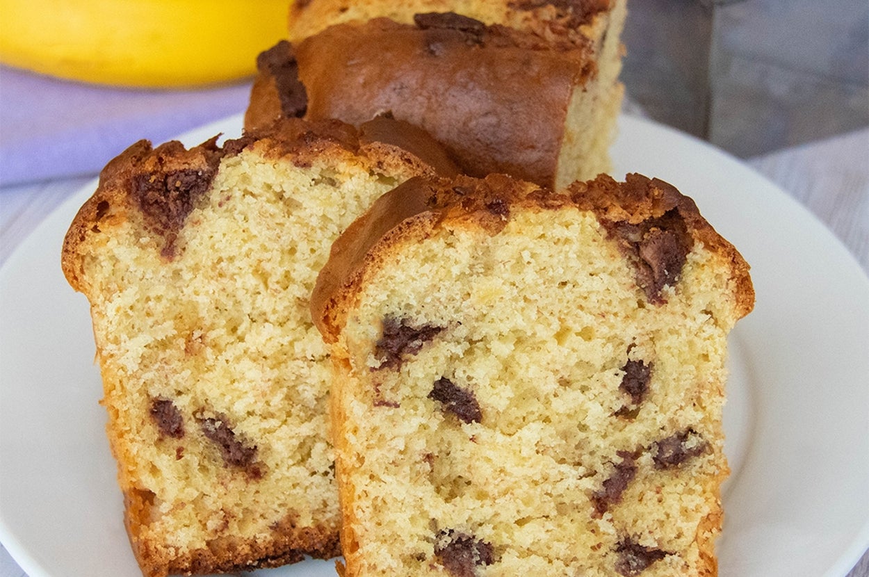 ホットケーキミックスで作ったチョコバナナパウンドケーキ。スライスが白いお皿に盛られている。背景にバナナと型に入った残りのパウンドケーキがある。