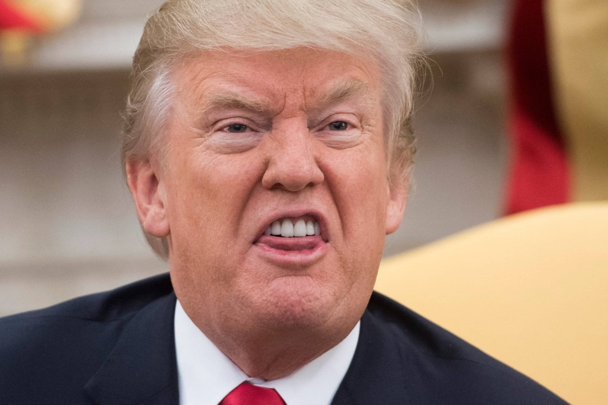 A person making a facial expression in a formal setting, wearing a suit and tie, suitable for an article categorized as "In the News."