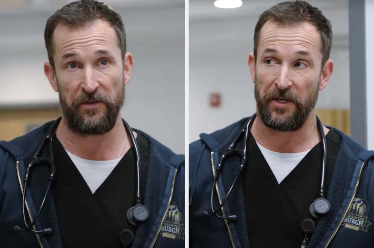 Man in medical scrubs and a zip-up jacket, wearing a stethoscope around his neck, speaking indoors