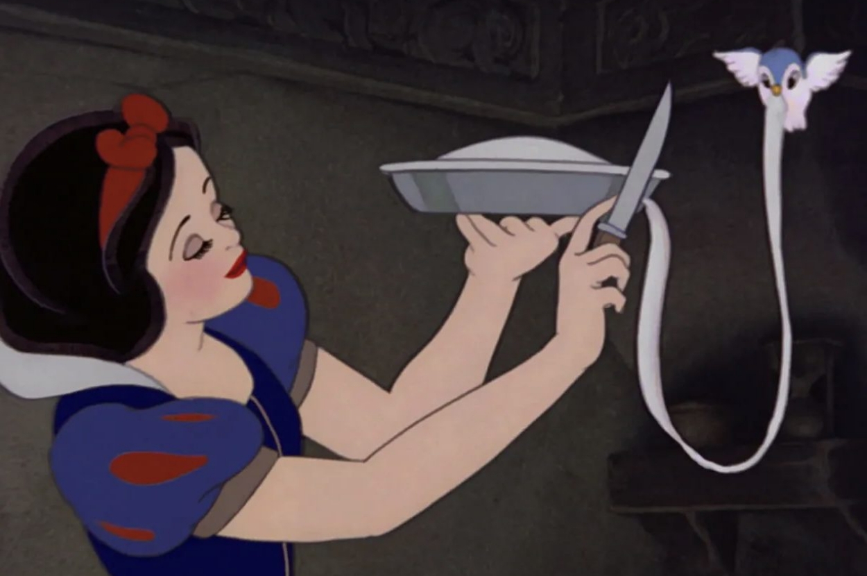 Animated character with short dark hair and a blue dress holds a pie. A bird pulls a long ribbon from the pie