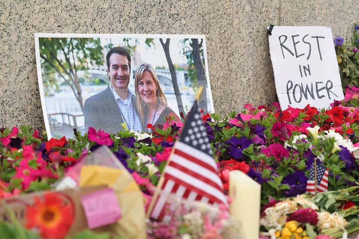 Memorial country with a couple's photograph among flowers, American flags, and a motion speechmaking "Rest successful Power."
