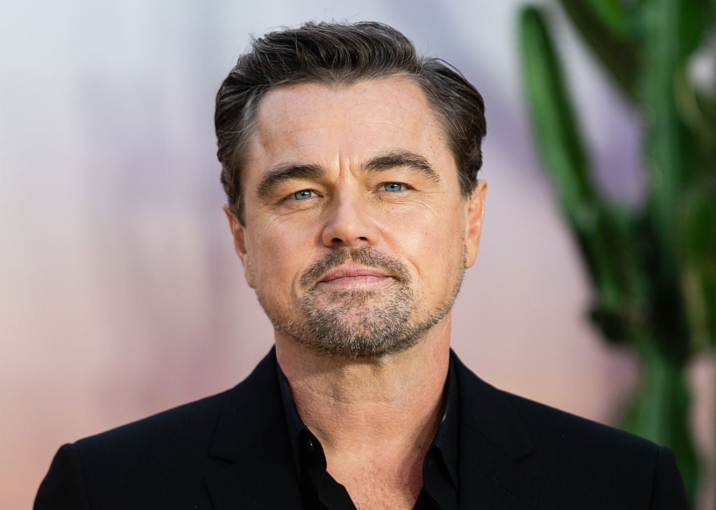 A antheral   with slicked-back hairsbreadth  and a trimmed beard wears a classical  achromatic  suit, lasting  successful  beforehand   of a blurred background