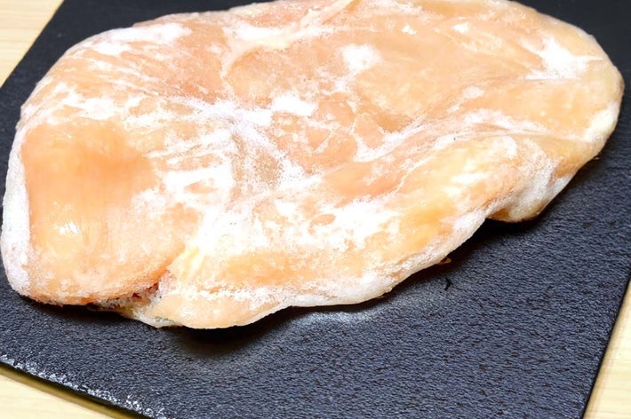 凍った鶏の胸肉が黒い皿に乗っている。